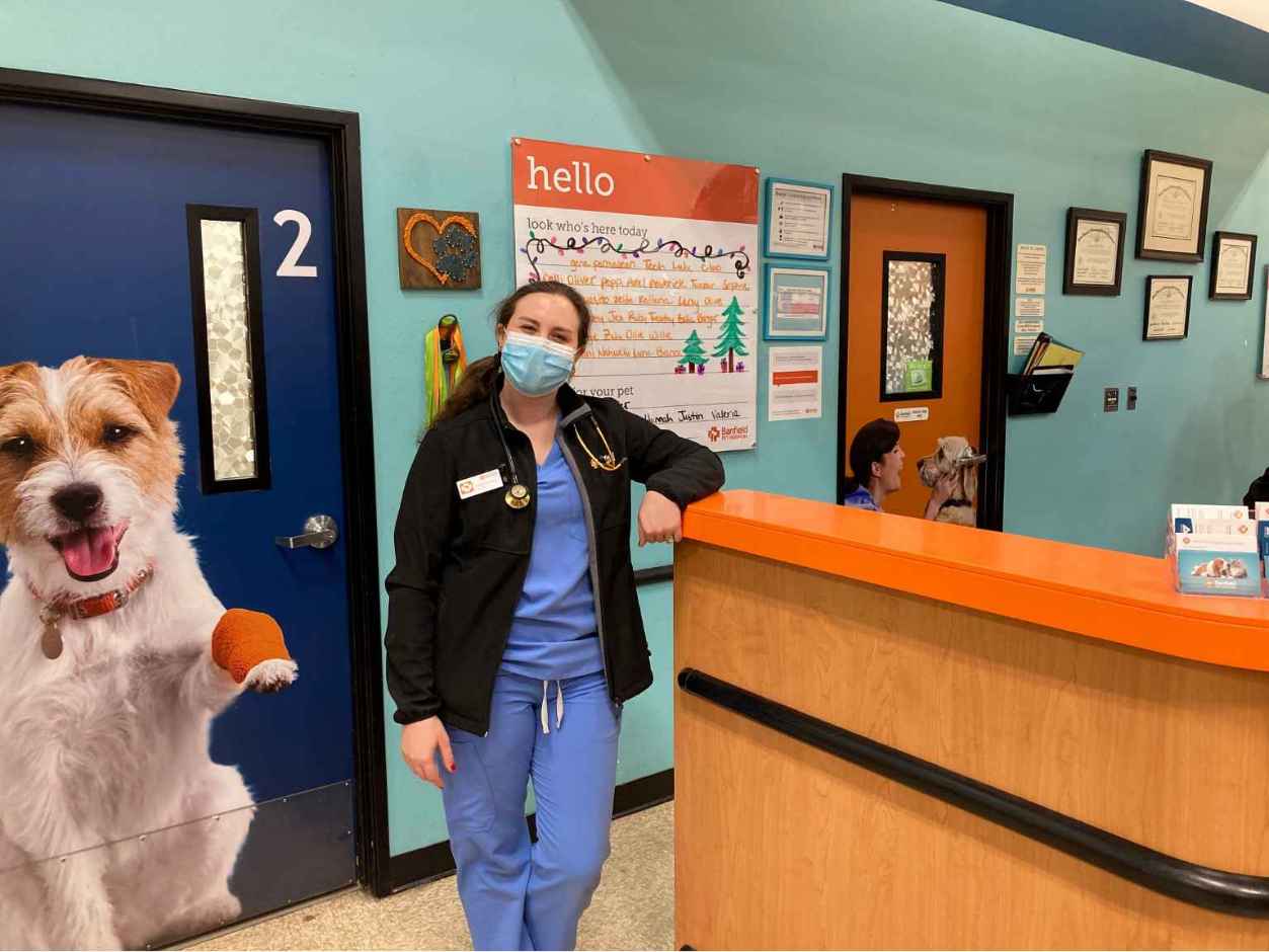 A female associate standing at the front desk of the Banfield Pet Hospital, Austin S, TX