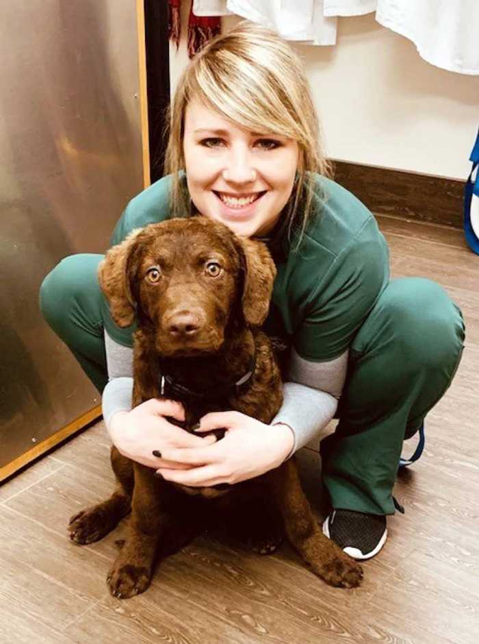 A young female veterinarian holding a brown dog at the Banfield Pet Hospital