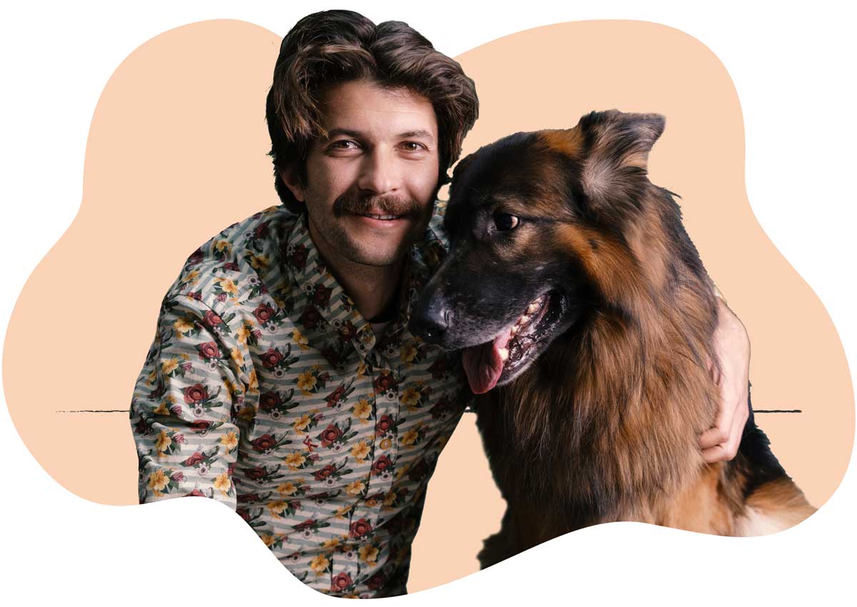 20250423_019 A man in a brown shirt sitting next to his shaggy brown-haired dog
