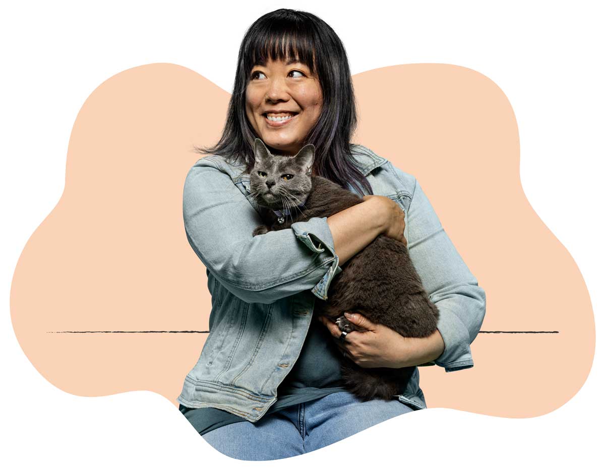 20250423_031 A woman in a denim coat holding her small gray cat in her lap