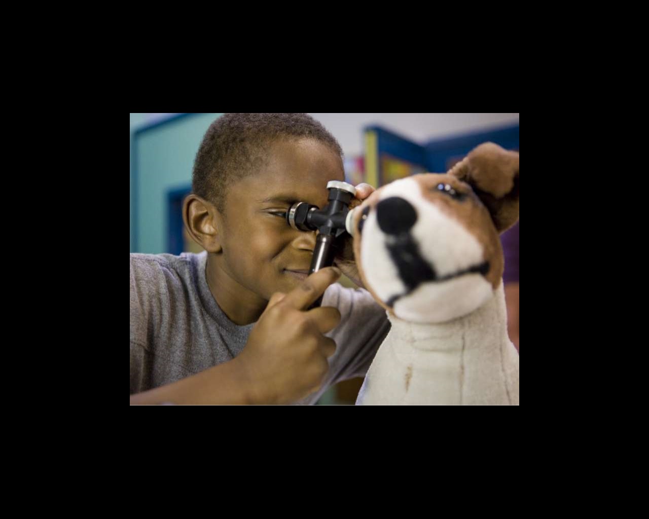Small boy playing with Dog doll