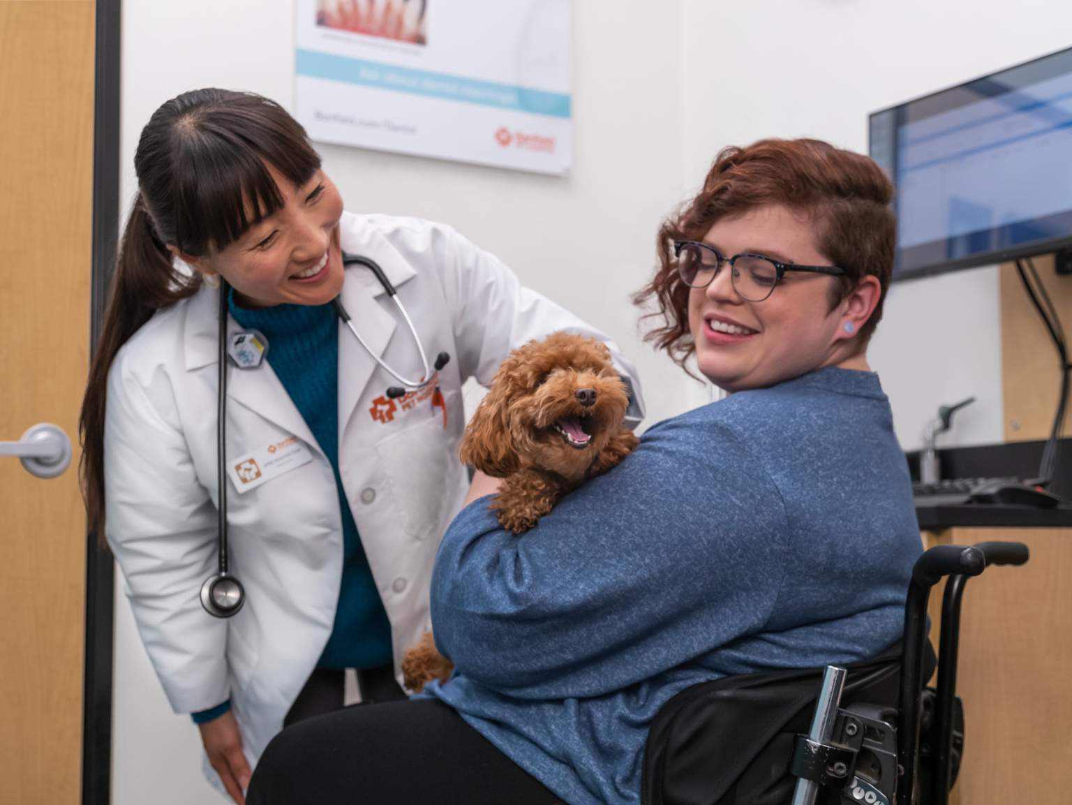 A young veterinarian and a dog owner with her dog at the Banfield Pet Hospital