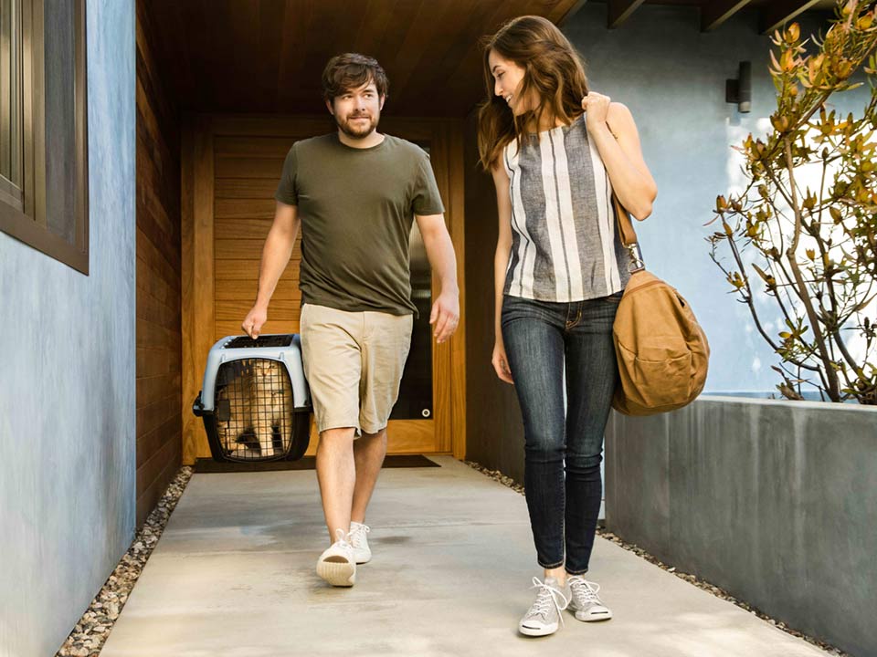 A man holding a cat in a carrier