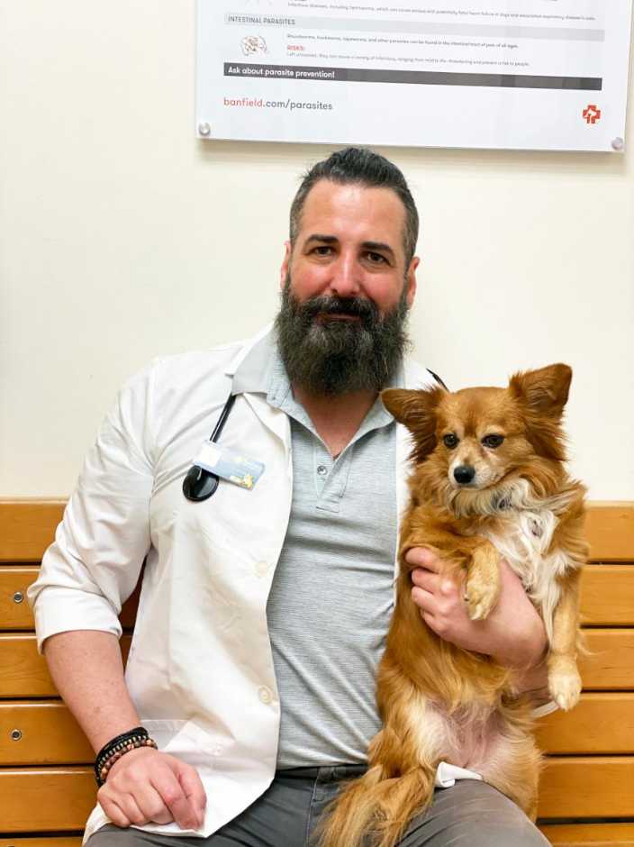 A male Banfield veterinarian with a dog