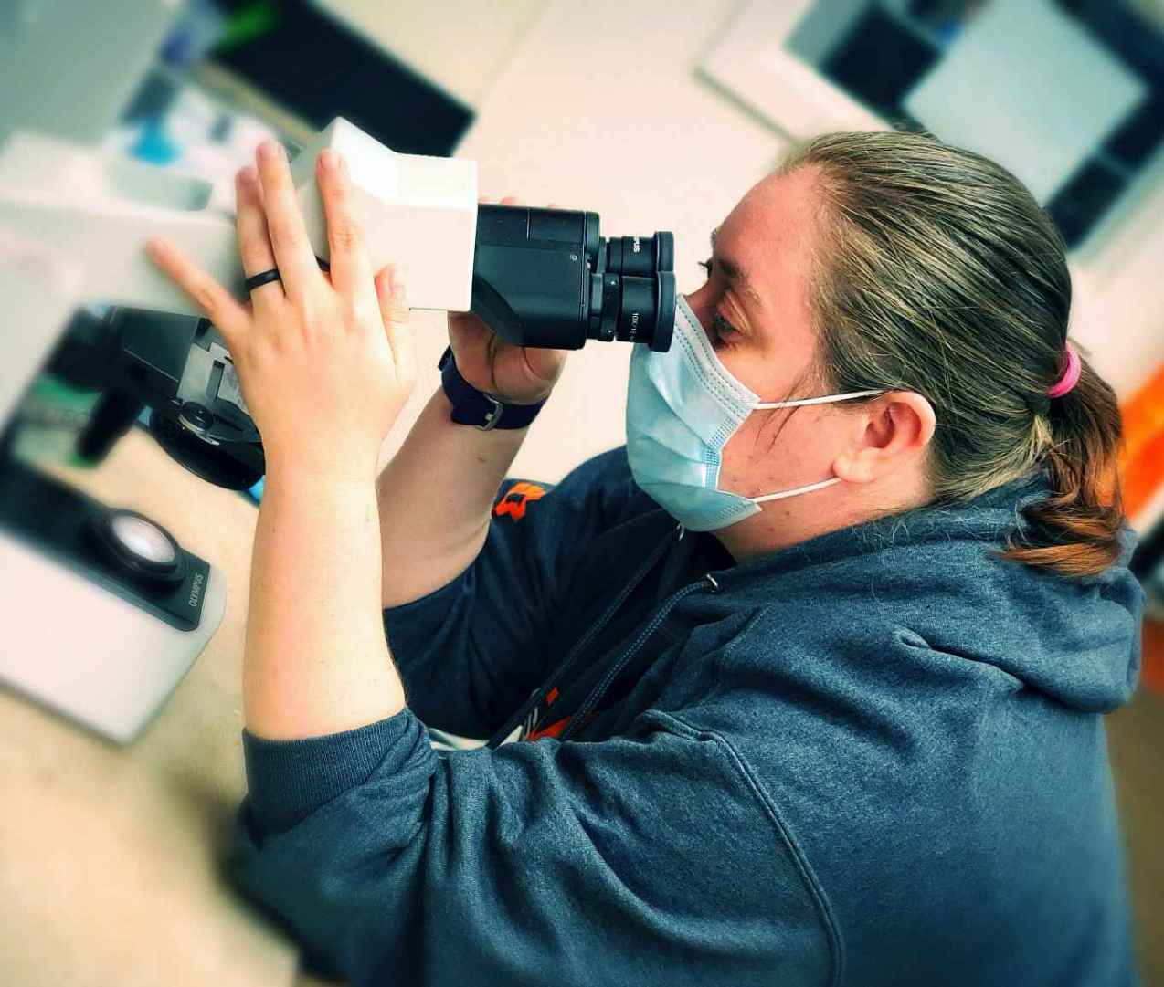 A female Banfield associate using a microscope at the Banfield Pet Hospital