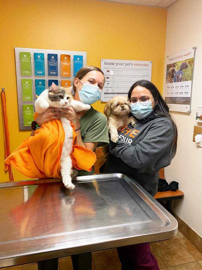 A couple of young female associates holding a cat and a dog at the Banfield Pet Hospital