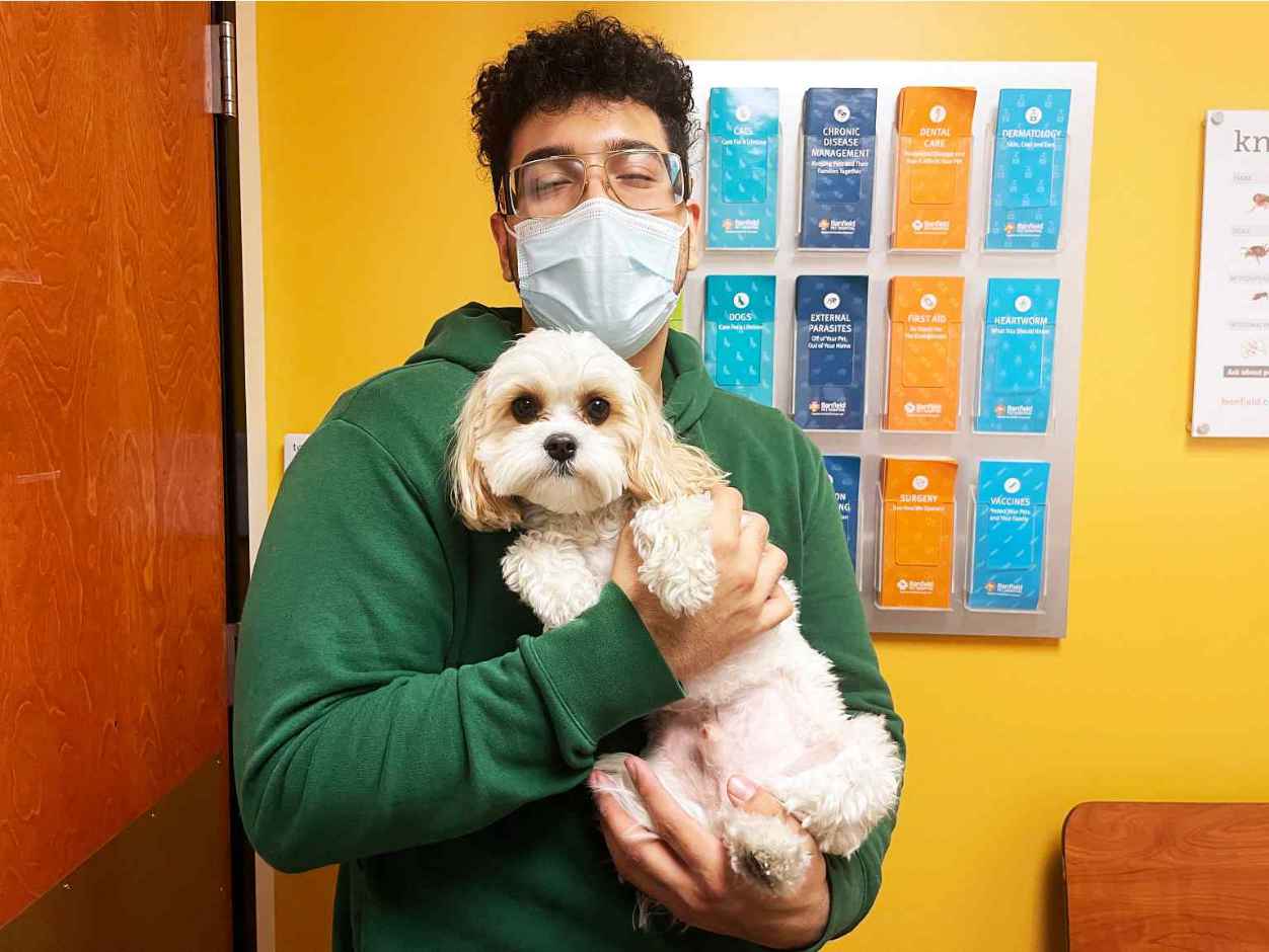 A male associate holding a dog at the Banfield Pet Hospital
