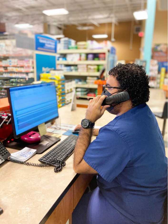 An associate sitting at his desk and talking on the phone