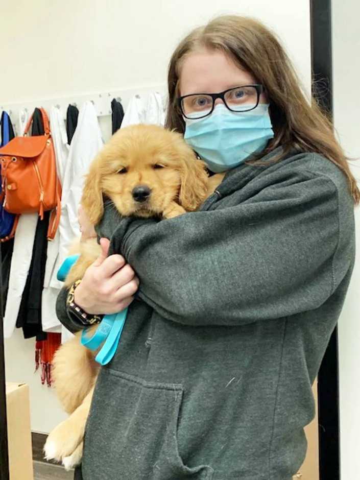 A young female veterinarian hugging a puppy at the Banfield Pet Hospital