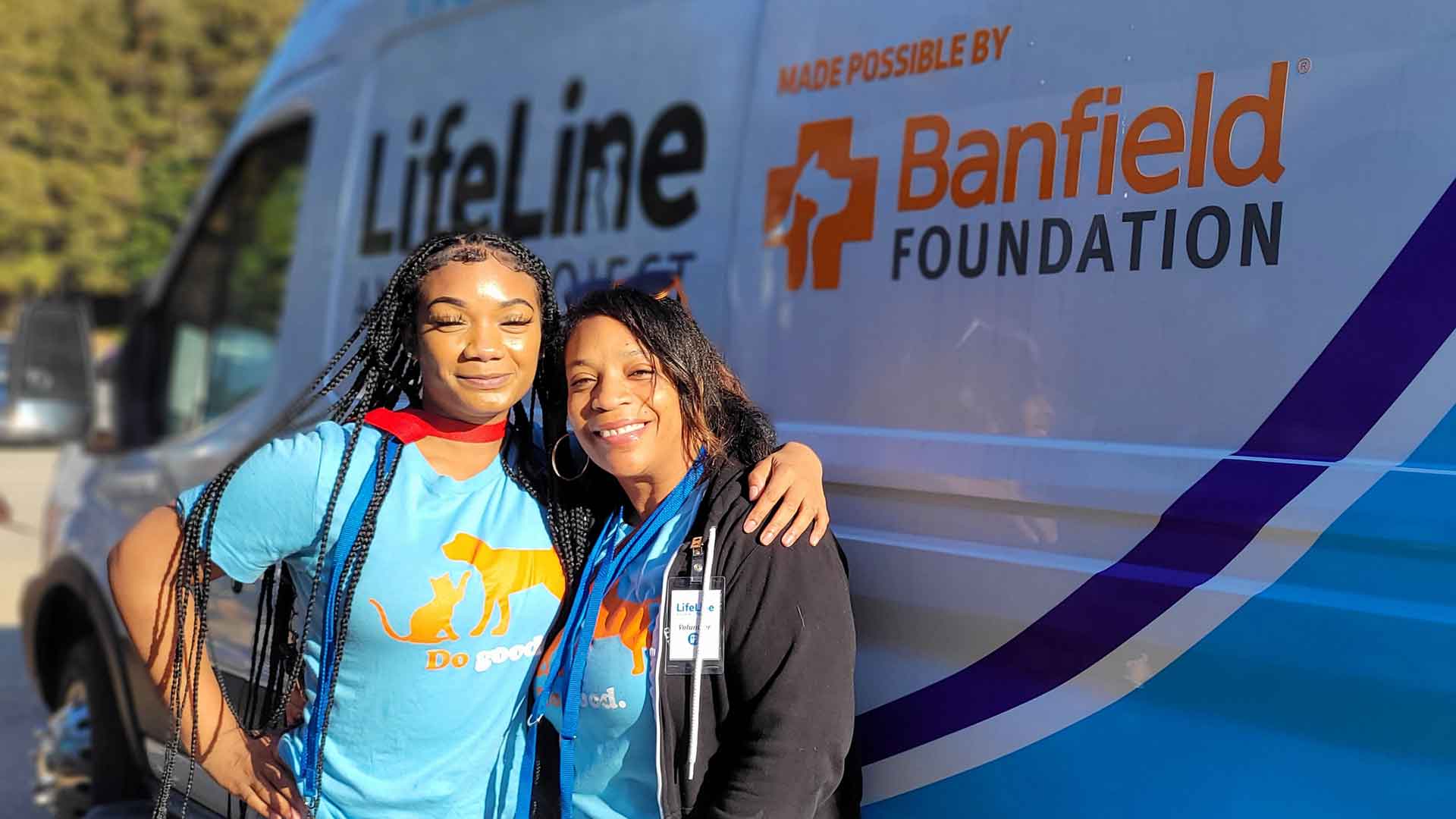 Two Associates standing in front of a Banfield Foundation van
